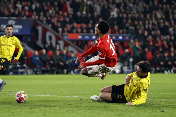 Malik Tillman pictured (center) in mid-air moments after being fouled by Mats Hummels (right) during PSV Eindhoven's 1-1 draw with Borussia Dortmund in February 2024